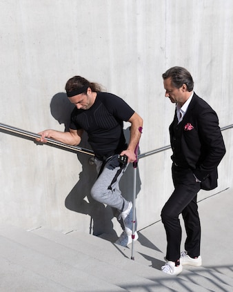 Michel Roccati and Grégoire Courtine walk up steps together. The steps are part of ongoing tests that Roccati undergoes with the team from .NeuroRestore.