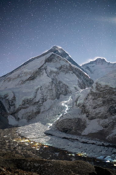 HEAD LAMPS ILLUMINATE THE PATH THAT CLIMBERS TAKE AS THEY MOVE UP THE KHUMBU ICEFALL ABOVE EVEREST BASE CAMP.