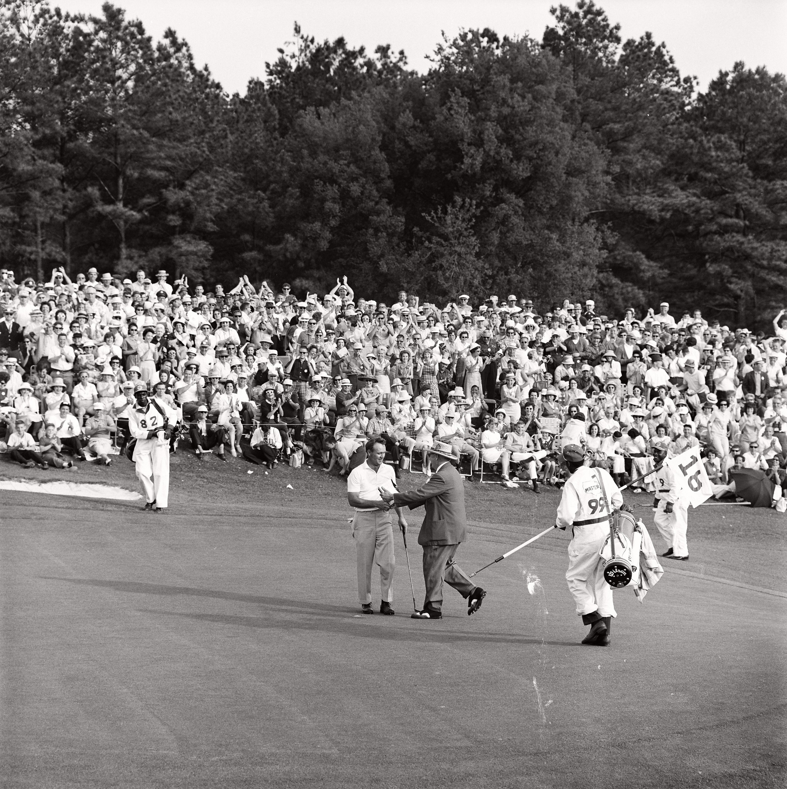 ROLEX TESTIMONEE ARNOLD PALMER IS CONGRATULATED BY AN OFFICIAL AFTER WINNING THE 1964 MASTERS TOURNAMENT