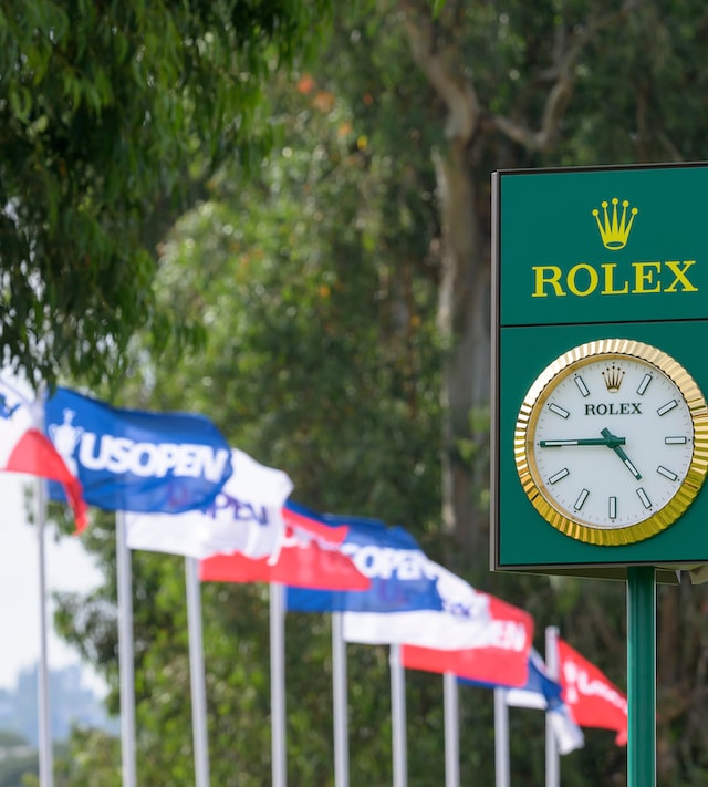 A ROLEX CLOCK IN FRONT OF THE U.S. OPEN FLAGS