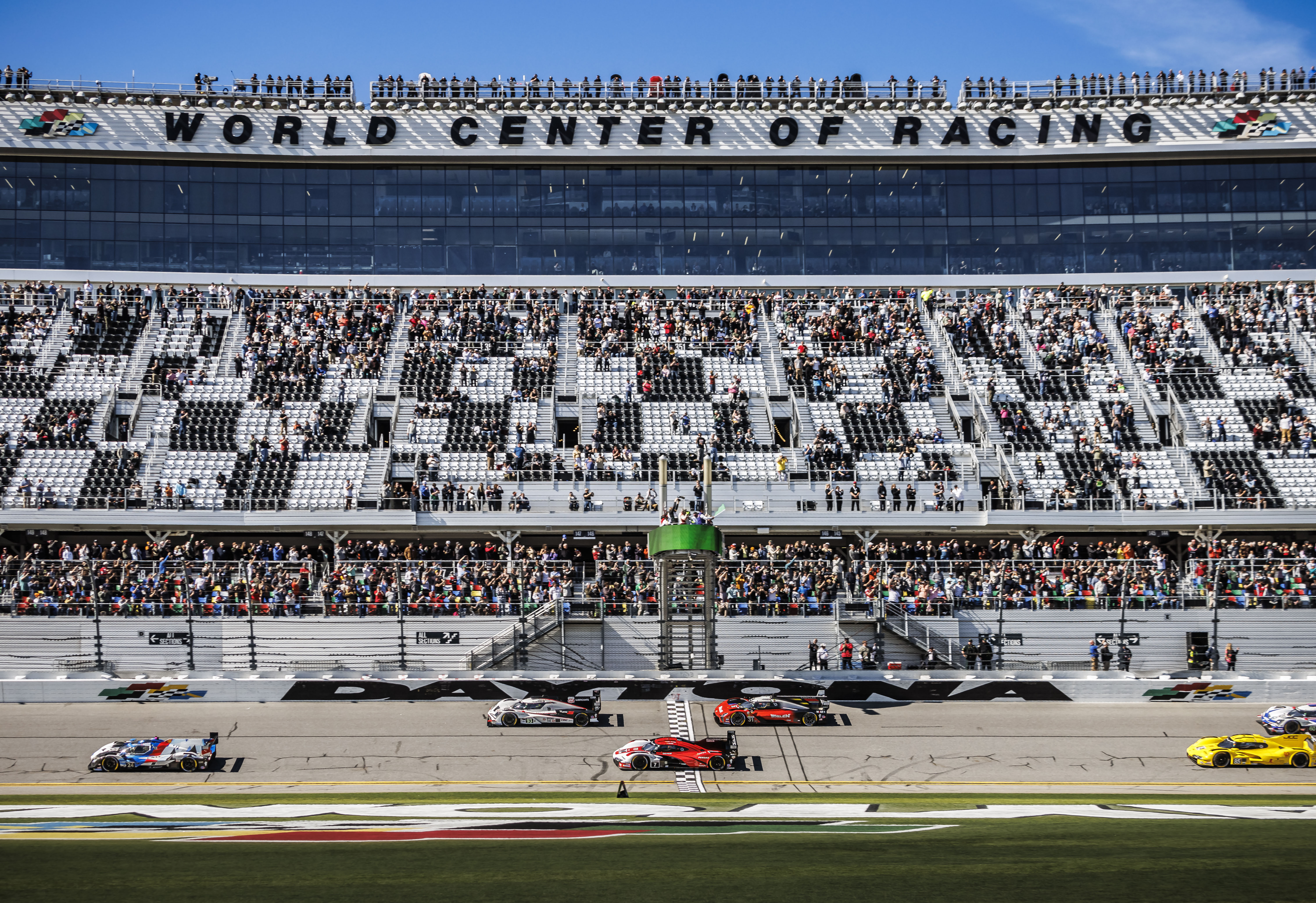 CARS CROSS THE START LINE DURING THE ROLEX 24 AT DAYTONA